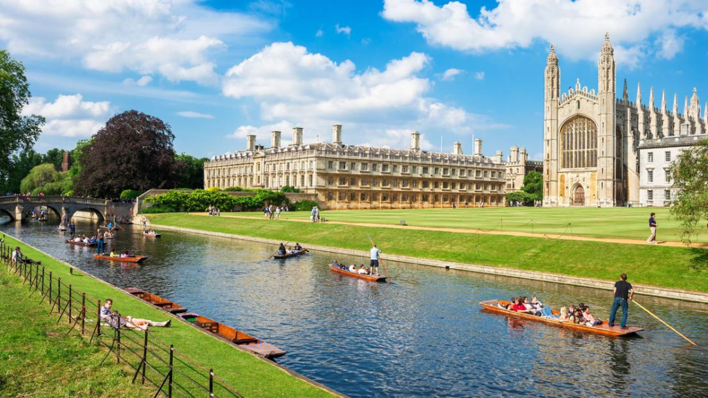 Quang cảnh Đại học Cambridge với tòa nhà cổ kính bên dòng sông, sinh viên chèo thuyền và dạo chơi trên bãi cỏ dưới trời xanh.